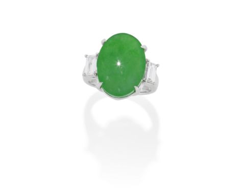 JADE AND DIAMOND RINGThe oval jadeite jade cabochon, weighing 14.40 carats, between step-cut diamond shoulders, diamonds appr