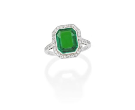 EMERALD AND DIAMOND RING, FIRST HALF OF THE 20TH CENTURYThe step-cut emerald within a surround of pavé-set single-cut diamond