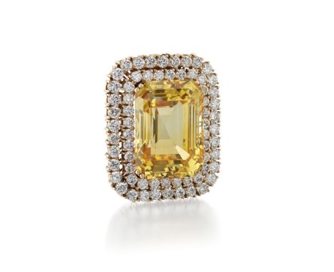 YELLOW SAPPHIRE AND DIAMOND BROOCH/PENDANTThe step-cut sapphire, weighing 70.07 carats, within a double surround of brilliant