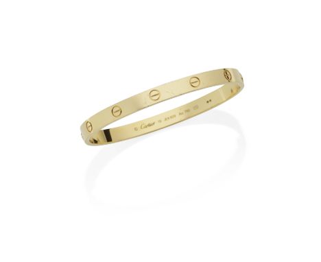 CARTIER: 'LOVE' BANGLEThe 18 carat gold polished oval bangle with screwhead motifs, signed Cartier, numbered, European conven