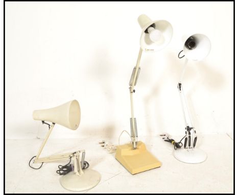A group of three vintage 20th Century angle poise desk top lamps, all having a white enamelled finish, two raised on round ba