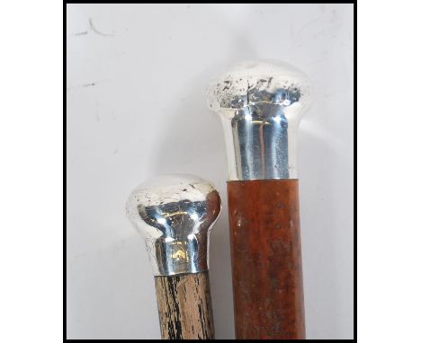 Two early 20th Century silver top walking stick canes of tapering form. One having a silver hallmarked knob handle with ebony