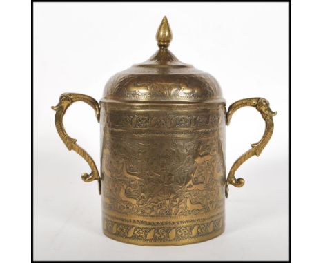 A 20th Century brass Persian lidded pot having repousse and engraved decoration depicting figures and animals amongst foliage