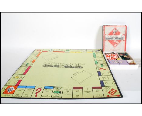 A vintage early 20th Century wartime Monopoly set in good condition, the playing pieces made from wood and card, money and ca