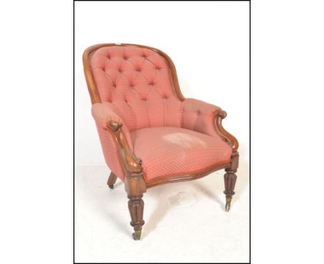 A Victorian 19th century walnut spoon back library armchair&nbsp; being raised on walnut turned legs with brass castors being