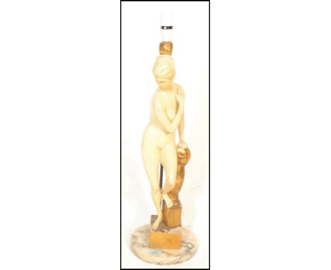 An early 20th Century chalk ware table lamp by&nbsp;Oliver Messel modelled as a classical figure of a nude lady leaning on a 