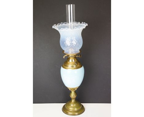 Early 20th Century oil lamp having a round stepped brass base with blue ceramic reservoir and opaline glass shade. Measures a