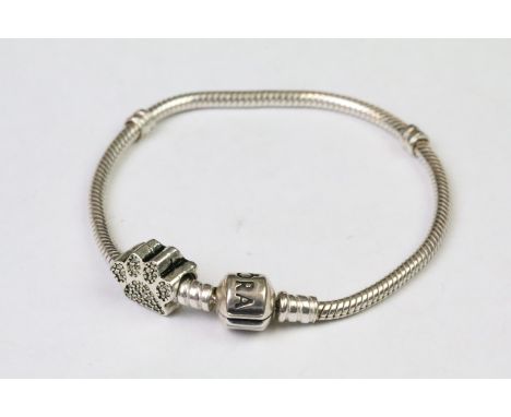 A genuine Pandora silver charm bracelet with a paw print charm, both marked 925 for sterling silver. 