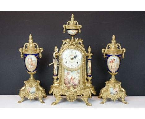 Early 20th Century mantlepiece garniture featuring a mantle clock with neo classical brass cased clock with ceramic figural p