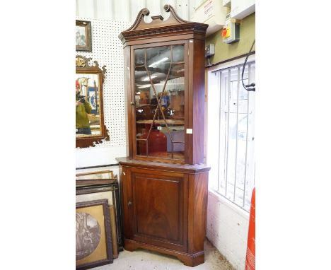 Mahogany Corner Cabinet in the George III Manner, the upper section broken swan neck pediment and single glazed door opening 