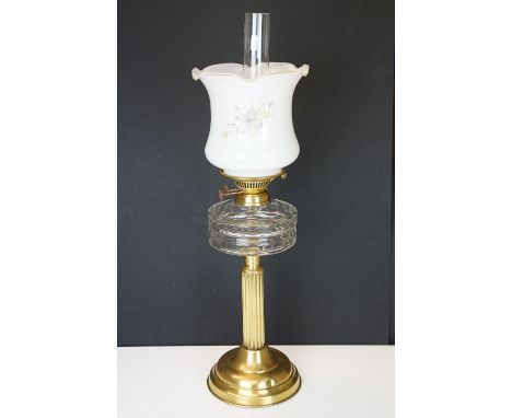 19th Century Victorian oil lamp having a fluted brass base, faceted glass reservoir, with fanned rim milk glass shade with fl