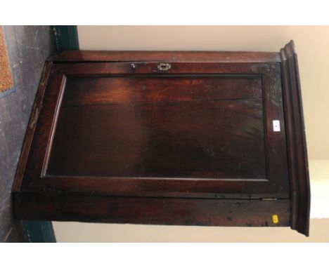 A Georgian oak-stained hanging corner unit with shaped cornice, with a panel door, shelved interior with brass escutcheon and