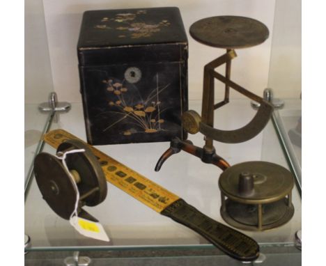 An eclectic range of household ornaments, to include two copper circular fishing reels, an old postal weighing scales, a cube