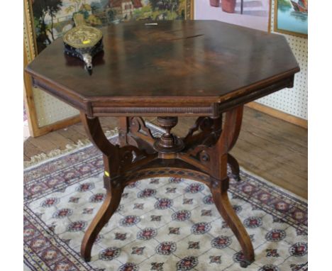 An Edwardian rosewood and flame mahogany octagonal centre table with profuse carving to the frieze, raised on cabriole legs, 