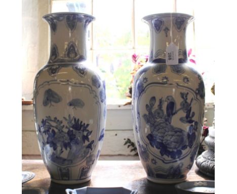 A pair of Oriental-style baluster shaped blue on white flower vases with floral, foliate and avian depictions, each 35cm high