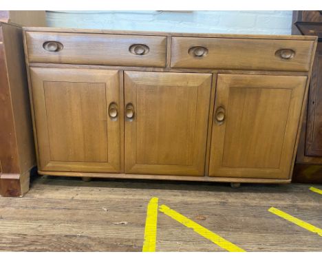 An Ercol Type Oak Sideboard. Circa 1950. Fitted with two long drawers above three cupboard doors. 81cm x 136cm x 46cm 