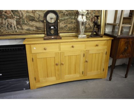 A SOLID LIGHT WOOD SIDEBOARD WITH THREE DRAWERS ABOVE THREE CUPBOARD DOORS AND INTERIOR GLASS SHELVES 