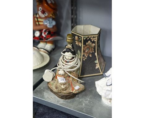 A JAPANESE TABLE LAMP, GEISHA GIRL SEATED WITH PUG IN ELABORATE GILT GOWN WITH COLOUR HIGHLIGHTS, ON WOODEN PLINTH BASE 