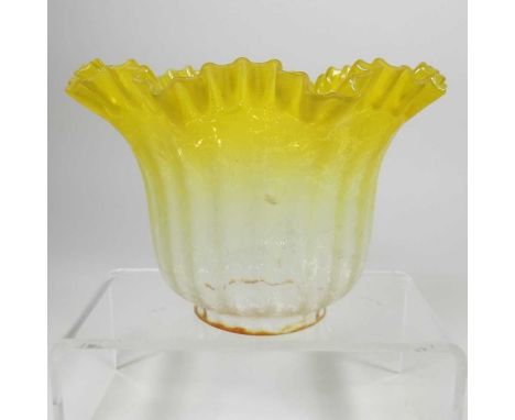 A small yellow glass oil lamp shade, with a frilled edge, 13cm highDirty with light surface wear. A rust coloured edge to the