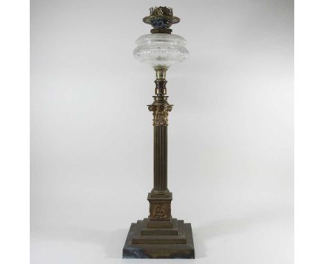 A brass telescopic Corinthian column oil lamp, with a glass font, extends to 94cm high