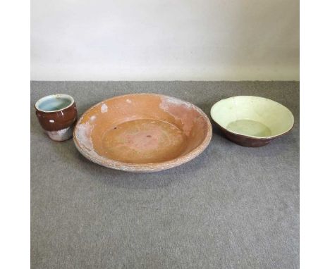 A terracotta dairy bowl, 80cm diameter, together with another smaller, a metal log rack, and a silver plated teapot on stand 