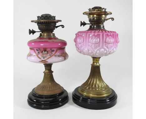 Two brass and pink glass oil lamp bases, highest 39cm (2)