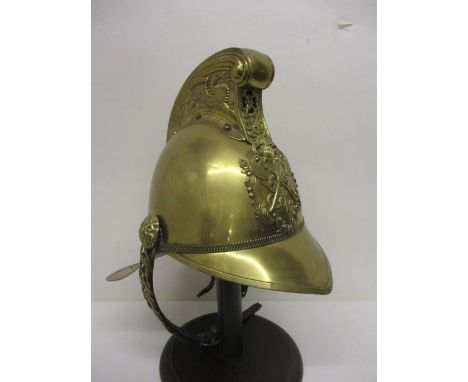 An early 20th century brass Merryweather fireman's helmet, the comb embossed with a winged dragon, a crossed axe badge to the