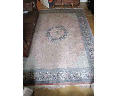 A Persian design carpet with a central medallion, foliage and flowers on a pink ground with green spandrels, 98" x 138" 