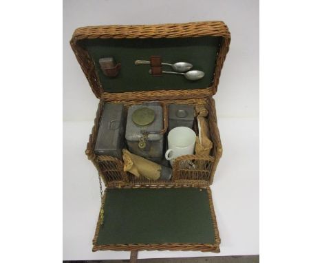 An early 20th century wicker picnic set, having a hinged top and fall front enclosing a kettle and burner, two metal canister