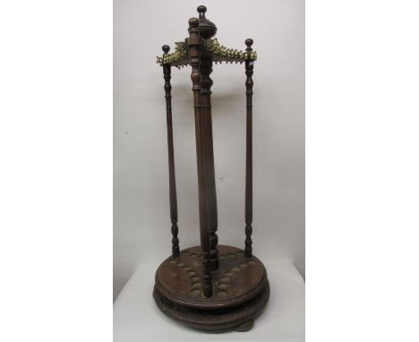 A Victorian walnut rotating snooker cue holder having turned finials, over turned columns and a platform base with provisions