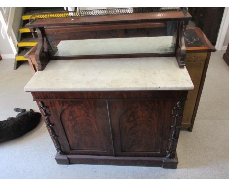 A William IV mahogany chiffoniere having a mirrored back with a brass, galleried shelf, over a marble top and twin panelled d