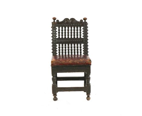 A late 17th century oak standard chair, with two rows of bobbin turned uprights, carved frame, scrolled cresting, turned knob