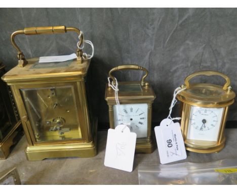 A brass carriage clock, of conventional form, with bold Roman numerals on an enamel dial 16cm high, and two miniature carriag