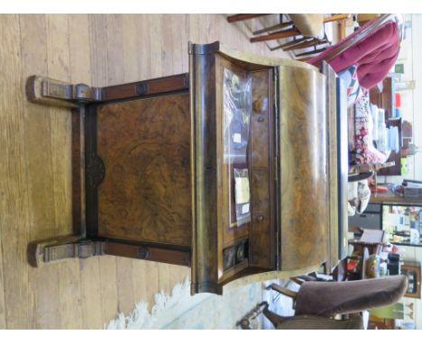 A mid Victorian burr walnut and ebonised Davenport desk, the rising top over a piano front enclosing sliding writing slope, a