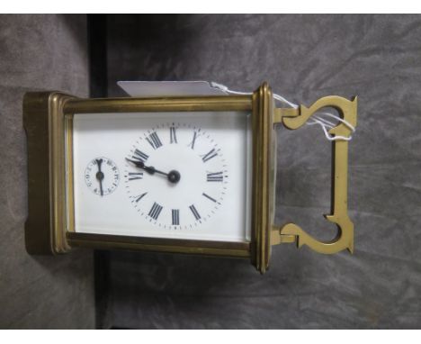 A brass carriage clock, of conventional form, the enamel dial with Roman numerals and alarm dial, the twin train movement str