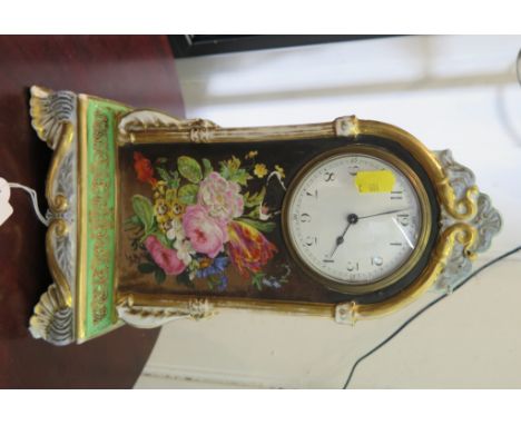 A 19th century porcelain mantel clock timepiece, the shaped case painted with floral sprays and green ground, the enamel dial