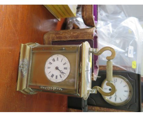 An Edwardian brass carriage clock, with bowed sides and applied foliate sprays, the circular enamel dial with a twin train re