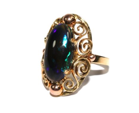 A 14 carat gold ring, set with oval black opal