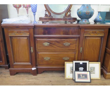 An Edwardian inverted breakfront sideboard, with frieze drawer over two graduated drawers flanked by panelled cupboard doors 