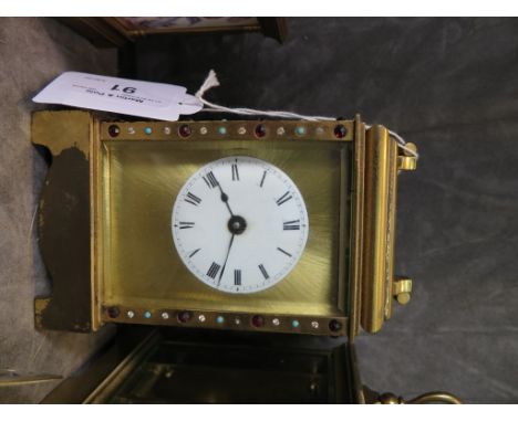 A Fema brass carriage clock with jewelled case and circular enamel dial, the movement requiring restoration 15cm high