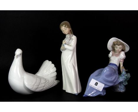 A Lladro dove and two Nao girl figures.