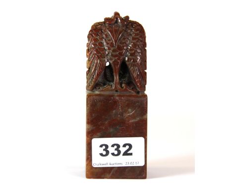 An unusual Chinese carved red soapstone seal, mounted with a winged mythical creature, H. 12cm.