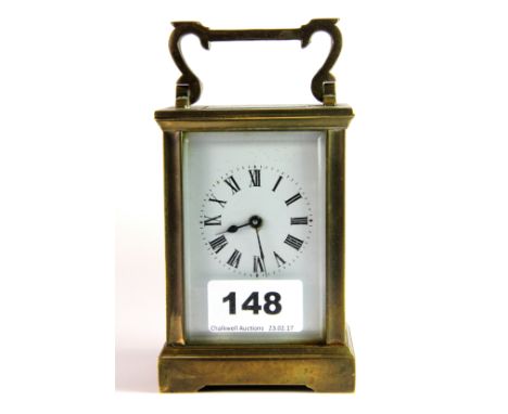 A 19th century brass and four glass carriage clock, with shaped swing handle, raised on four bracket feet, the white enamel d