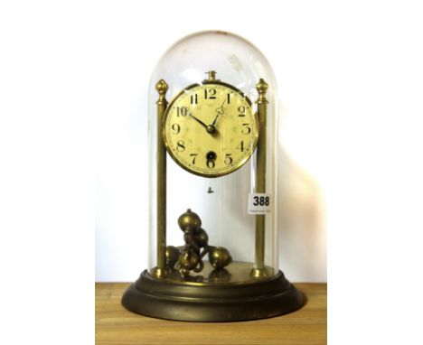 A vintage four hundred day brass mantle clock with plastic dome.