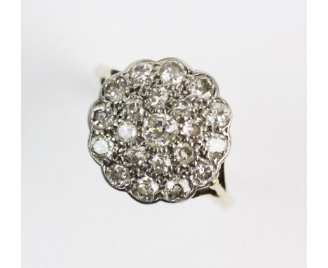 A diamond set floral cluster ring, comprising, 21 old cut and single cut diamonds all set in a scalloped white metal surround