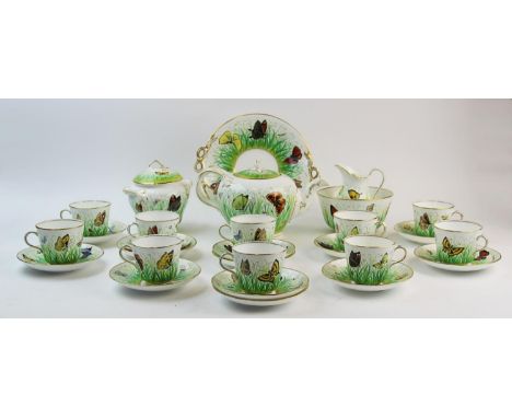 A 19th century butterfly pattern tea service, in the style of Wedgwood, adorned with vibrant butterflies above a green foliat