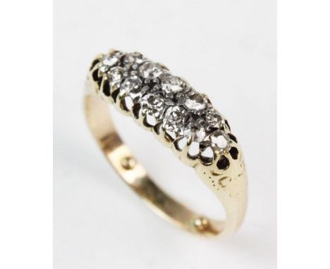 A diamond set two-row ring, comprising 12 small mine cut diamonds, claw set to a yellow metal pierced design gallery, continu