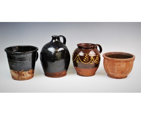 A collection of terracotta vessels, probably 19th century, comprising; a treacle glazed slipware jug of inverted baluster for