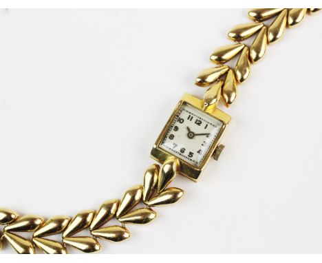 A lady's 18ct gold cocktail watch, white rectangular dial with gold toned Arabic numerals, set to a plain polished yellow gol