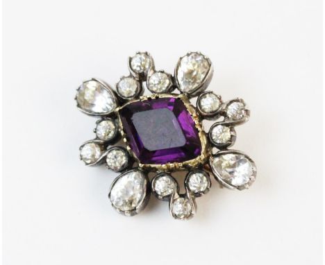 A Victorian paste set cluster brooch, comprising a central step cut purple paste set in yellow metal with a cluster surround 